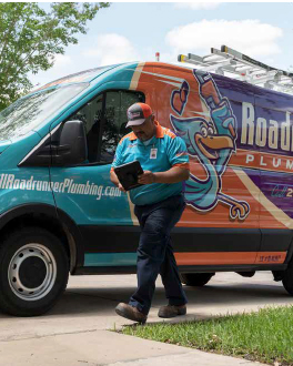 Road Runner Plumbing technician walking next to van getting ready for a plumbing inspection