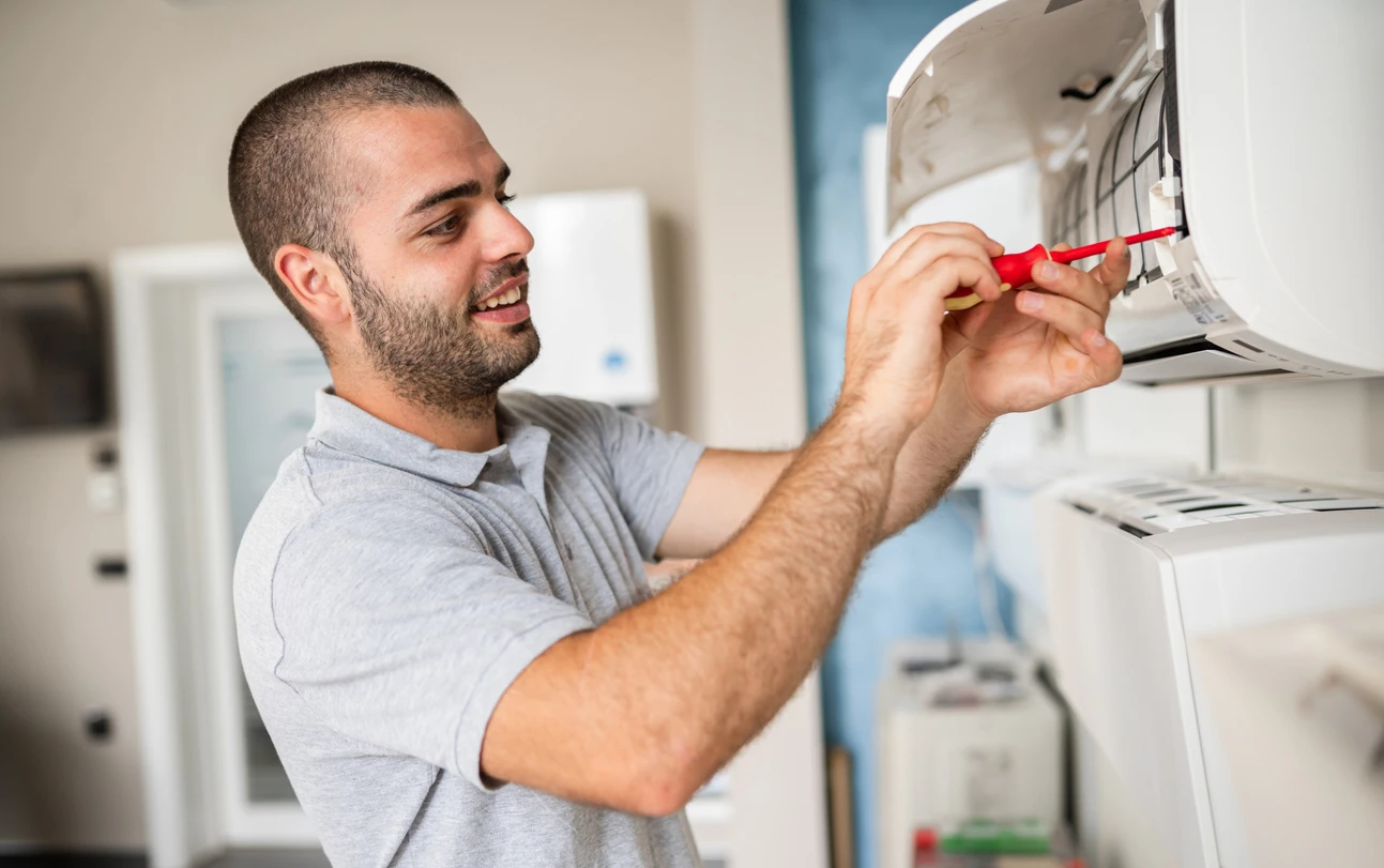 A technician repairs an air conditioner