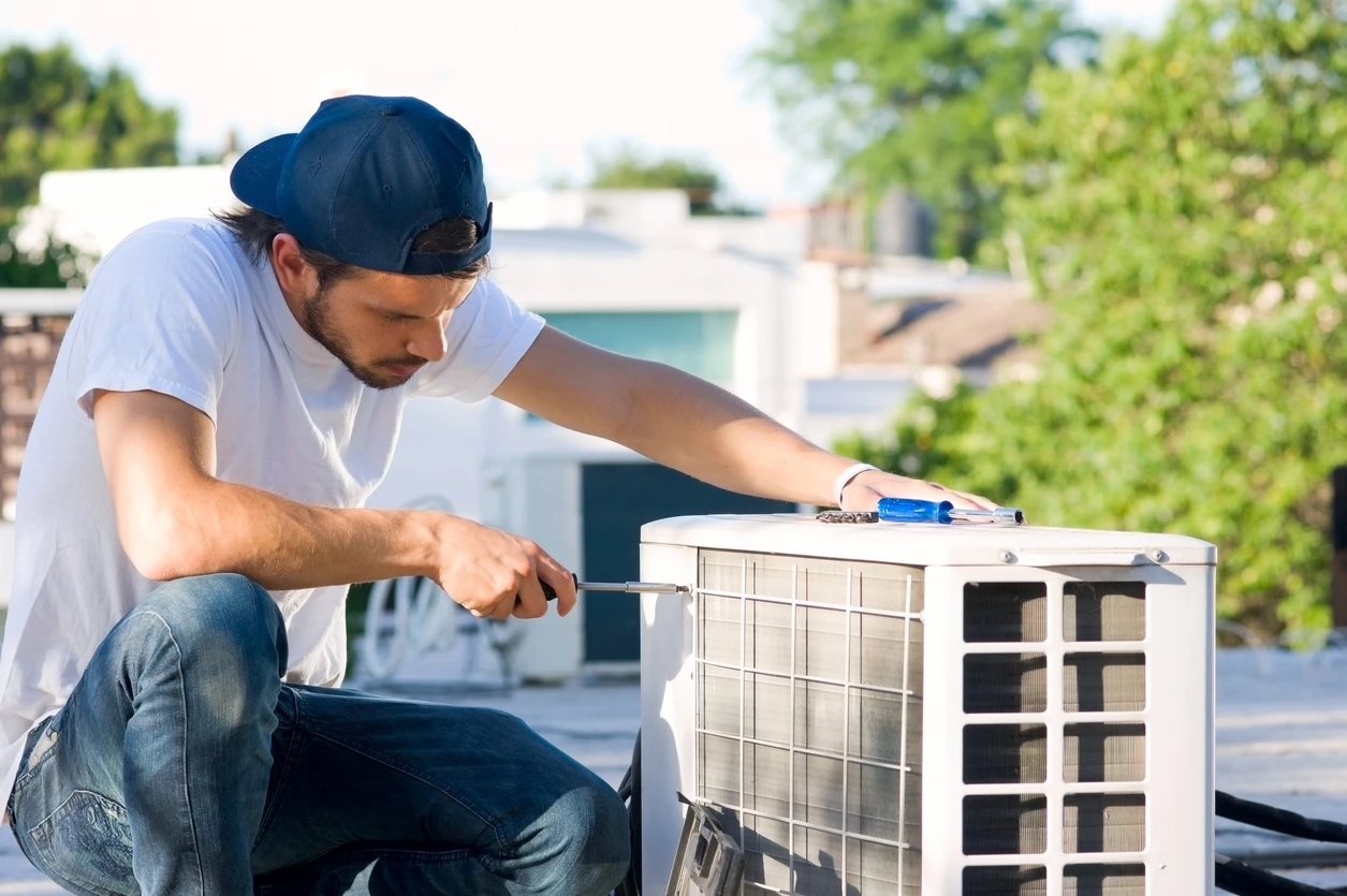 A man is engaged in fixing an air conditioning system