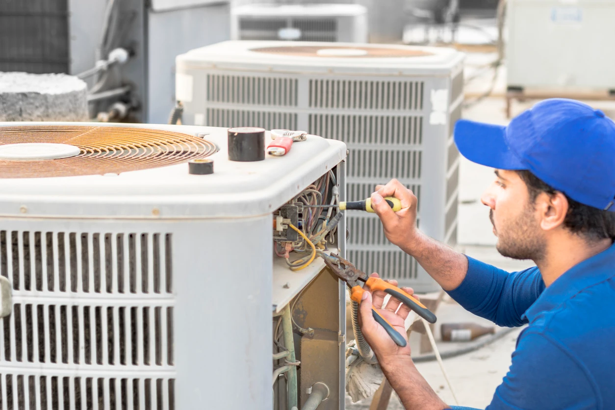 A skilled technician adjusts an air conditioner