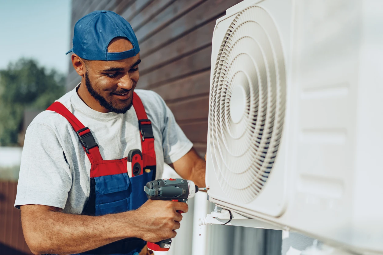 A skilled technician adjusts an air conditioner