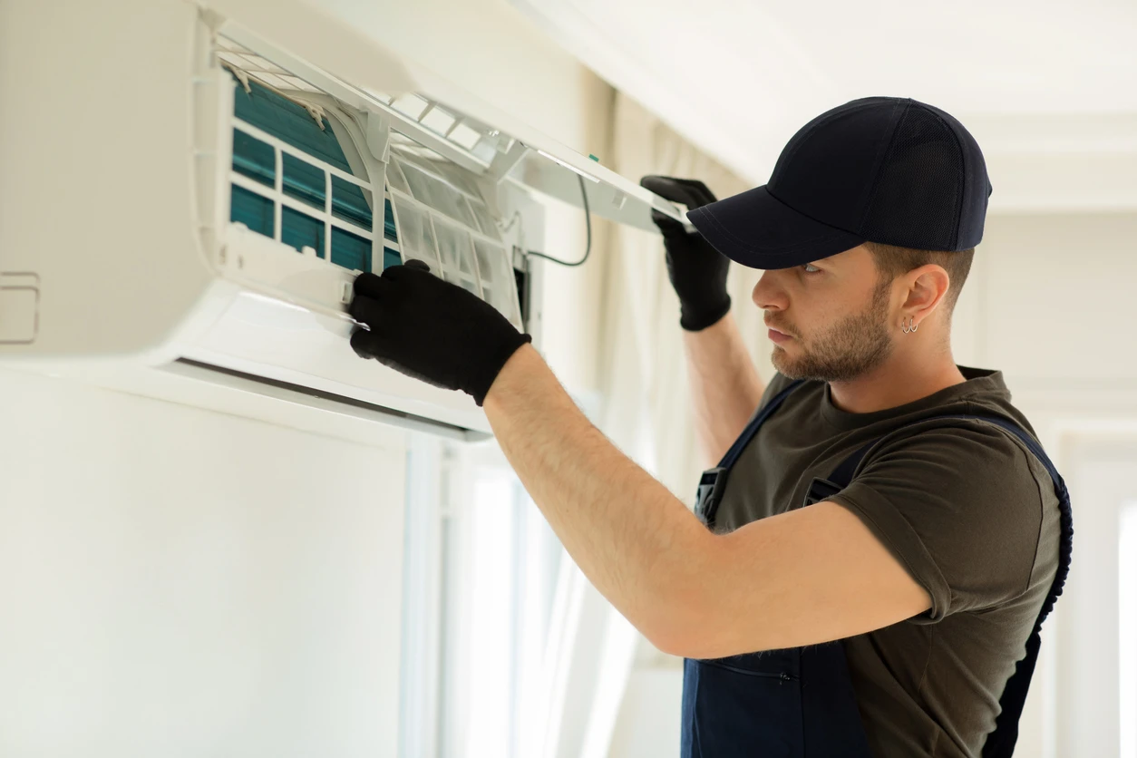 A man works on an air conditioning unit
