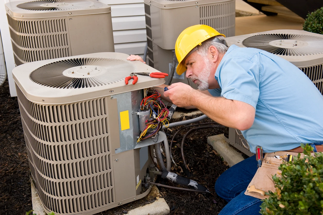 A technician repairs an air conditioner