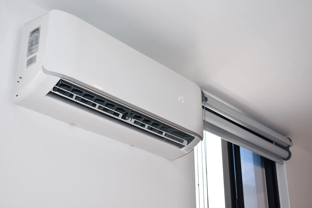 Wall-mounted white air conditioner providing cool air