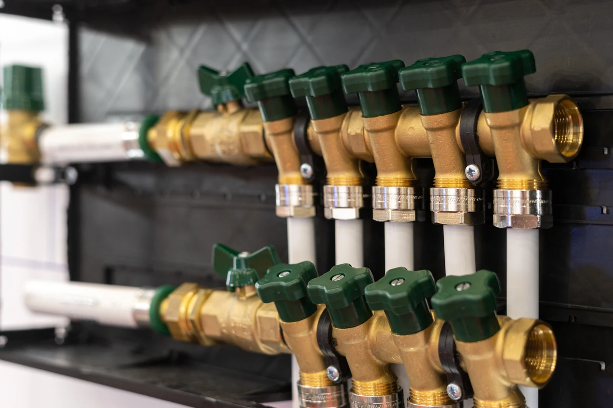 Group of brass and green valves fixed to a wall