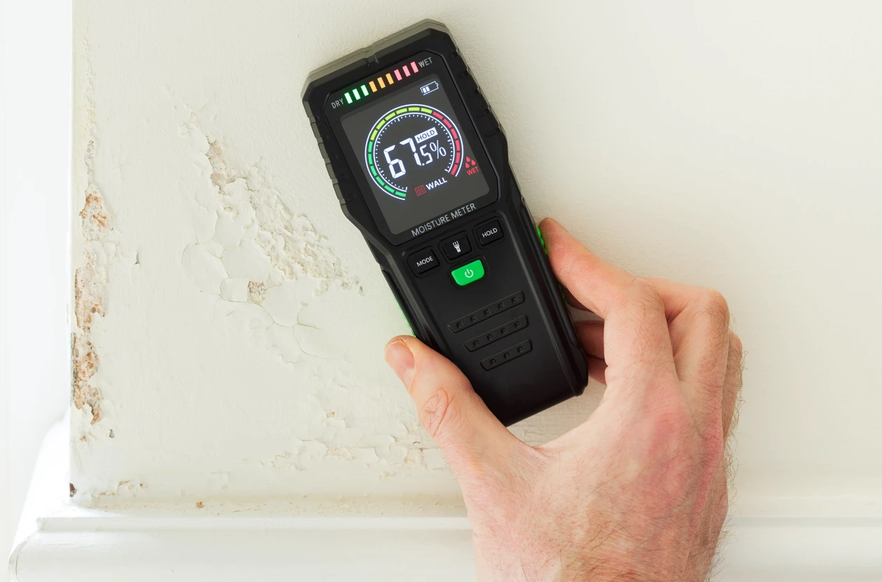 A plumber checking and measuring a leak.