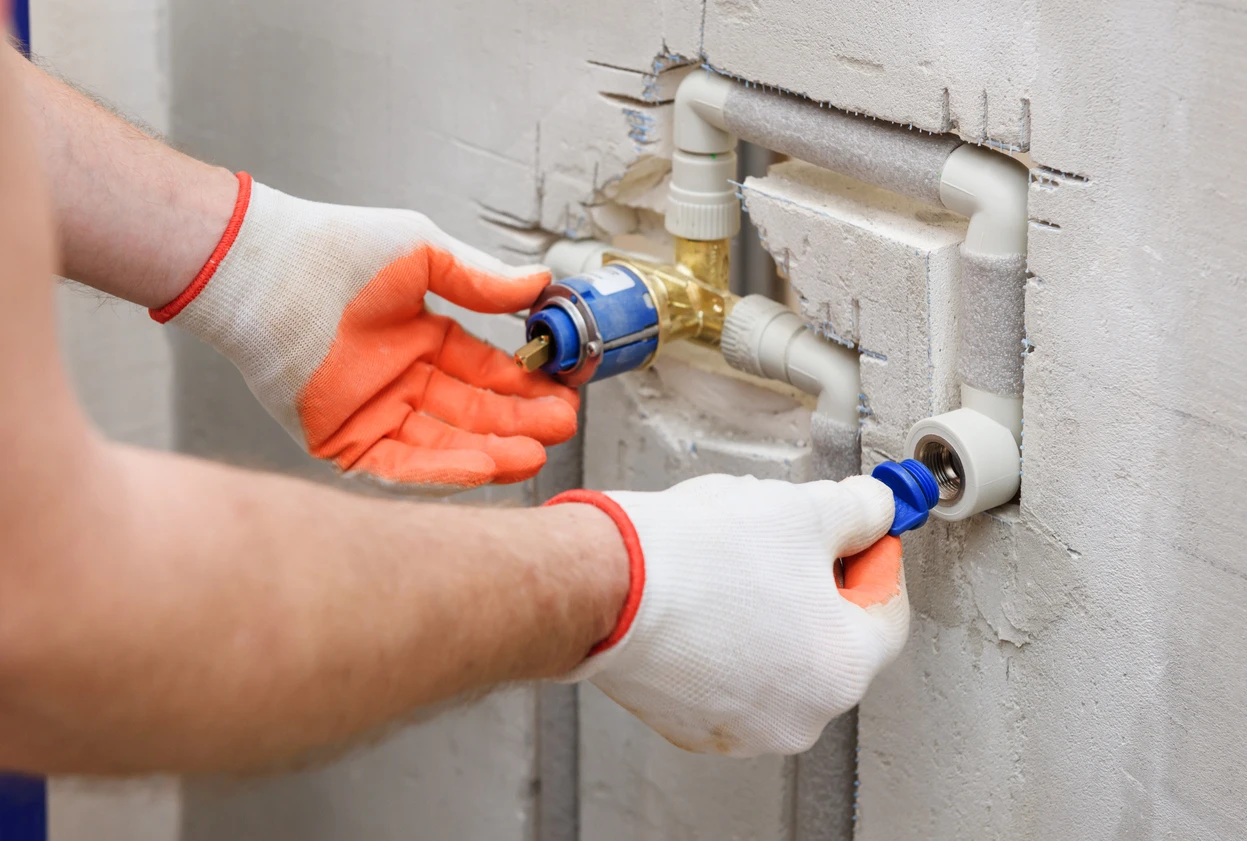 A plumber is repairing a water valve